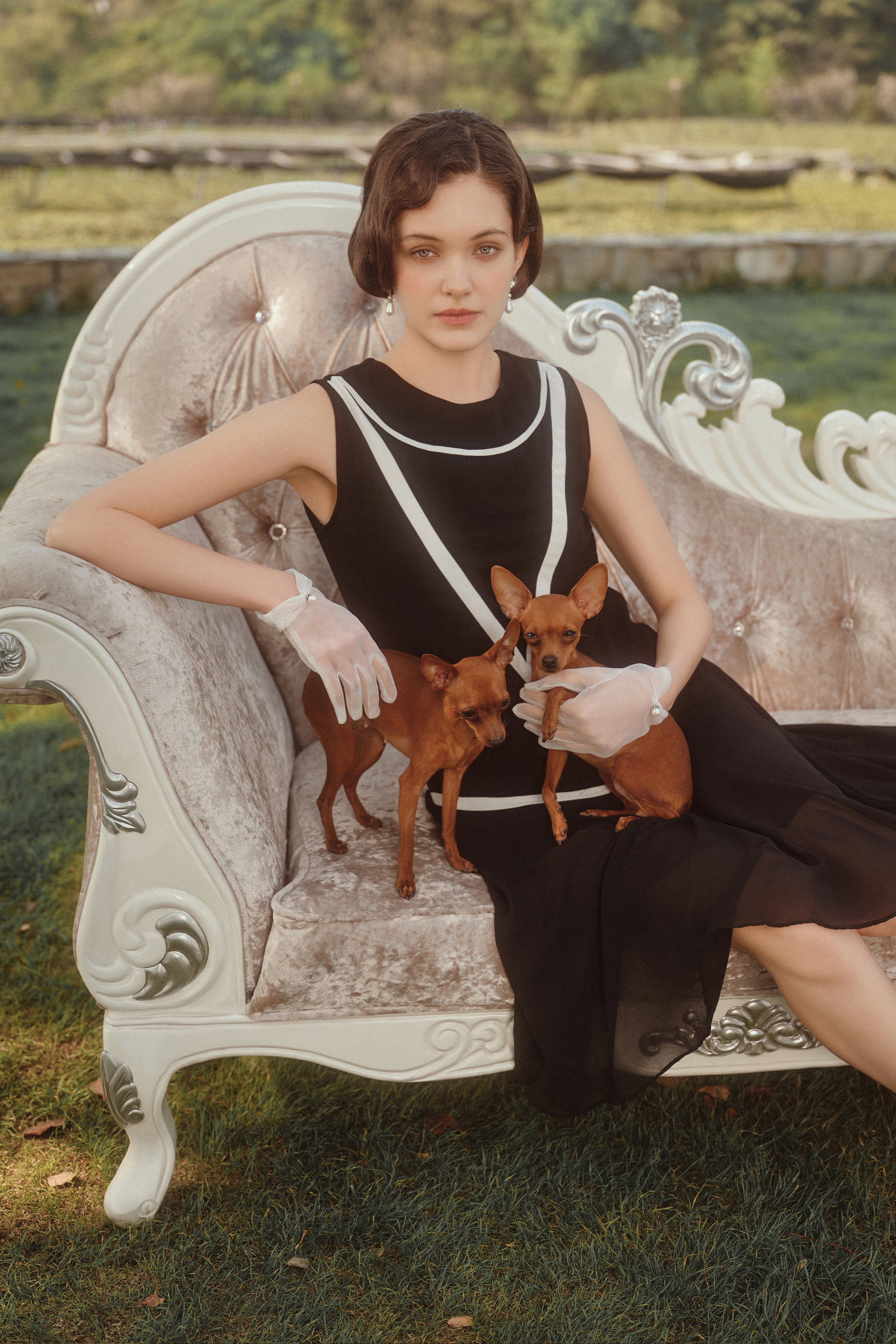 a woman in a black 1920s dress accented with white straight lines and she's wearing a black cloche hat for a more casual occasion