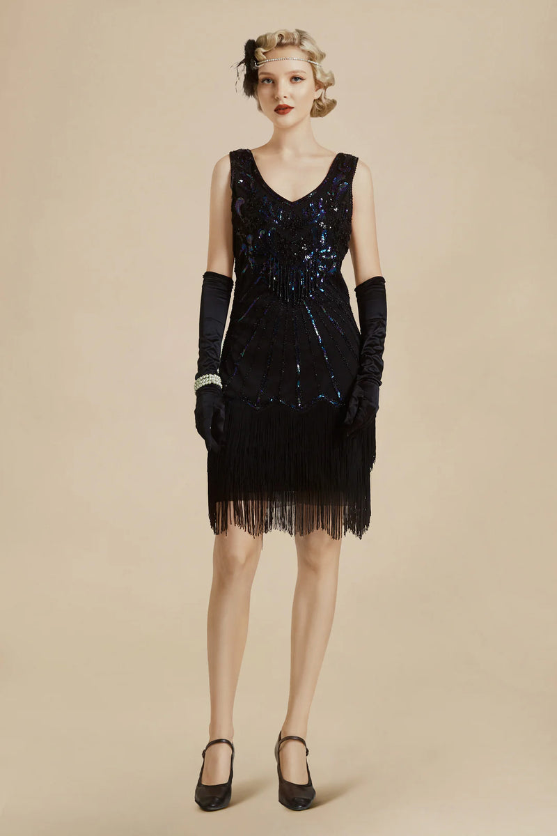a woman in black wearing 1920s Great Gatsby dress with a tasseled hemline that is above the knee, black gloves, and black ankle-strap shoes 